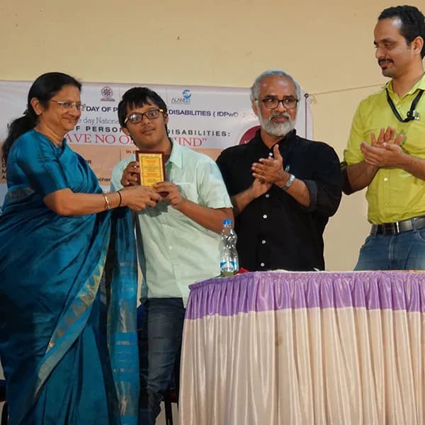 Guests on stage with a young award recipient