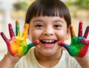 A child laughing and showing hands covered in colourful paint
